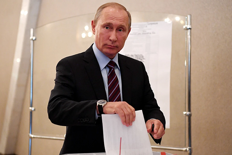 Владимир Путин в отличие от многих к плакатам с портретами не пошел, а сразу направился к столу с бюллетенями