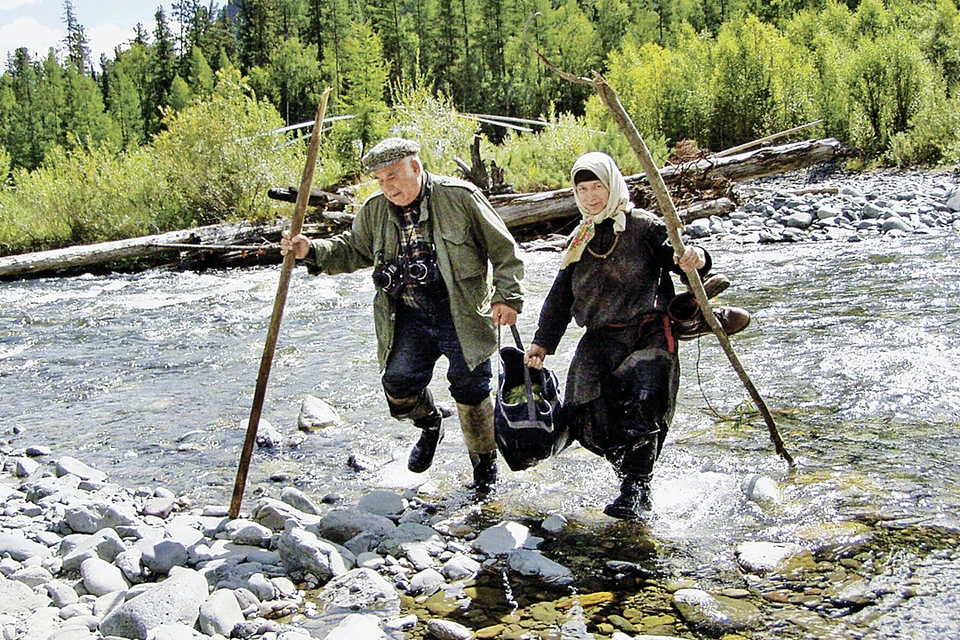 Василий Михайлович и отшельница Агафья пробираются через таежный ручей к ее заимке. Фото: Владимир ШЕЛКОВ/TASS
