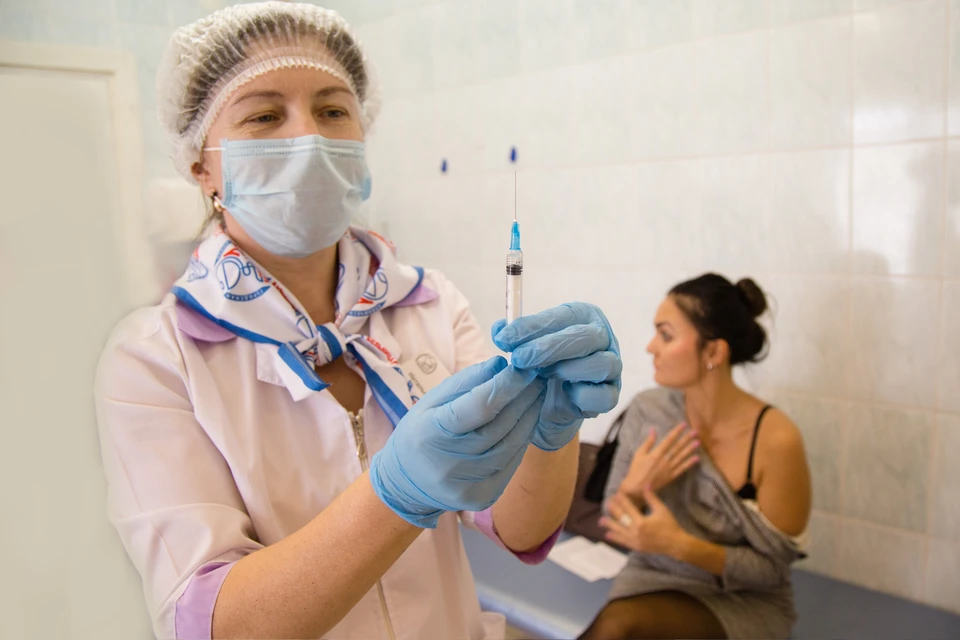 Медсестра во время вакцинации населения от гриппа в поликлинике.