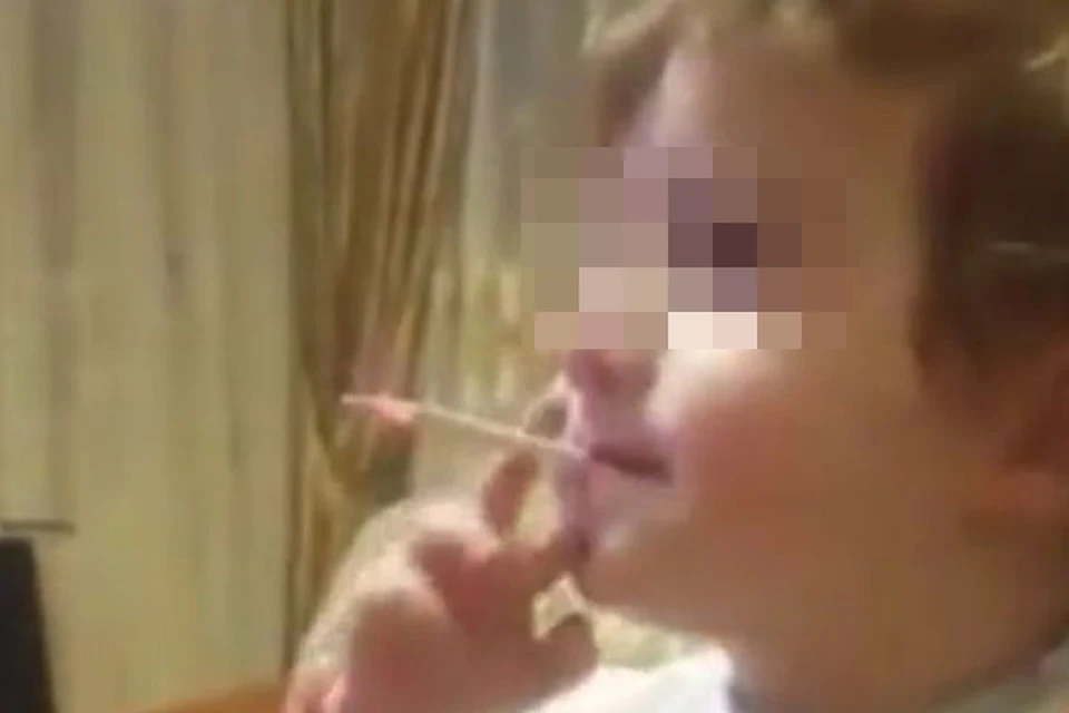 Младенец, которому от силы два года, умело обращается с сигаретой — часто затягивается, пускает дым и ловко стряхивает пепел своими маленькими пальчиками. Фото: скриншот видео