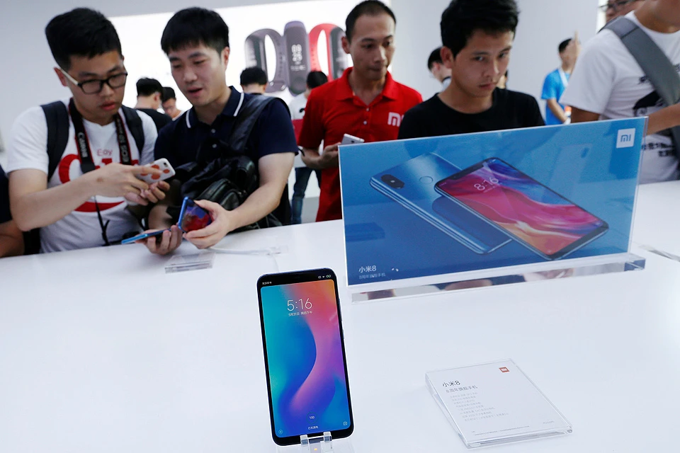Посетители презентации Xiaomi у стенда с новинками.