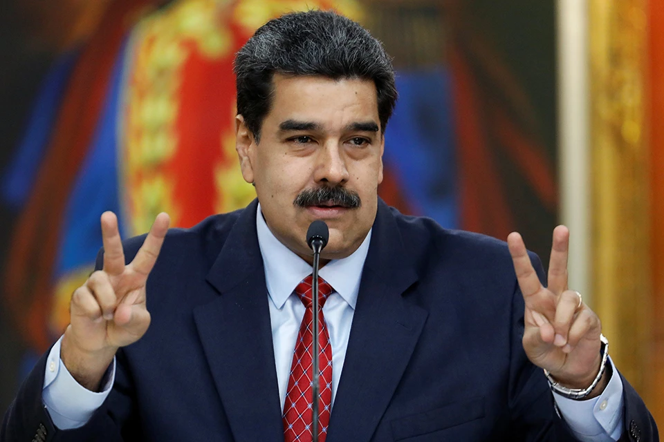 Президент Венесуэлы Николас Мадуро демонстрирует победные жесты на пресс-конференции.