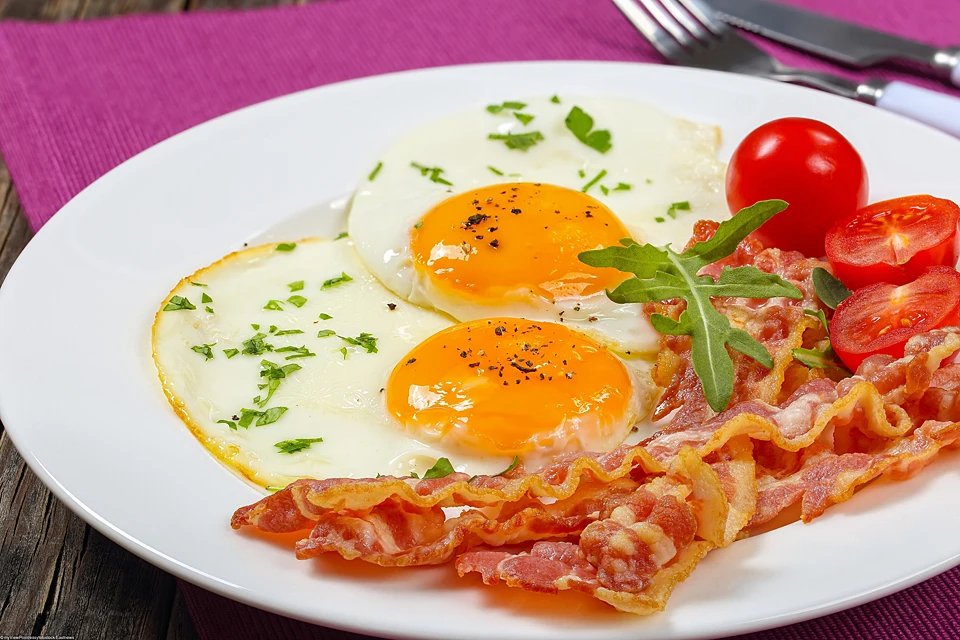 Яичница станет значительно полезнее, если добавить к яйцам помидоры или лук