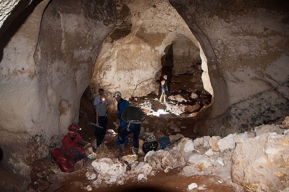 Дно пещеры выстлано кирпично-красными отложениями. Фото: Российский союз спелеологов