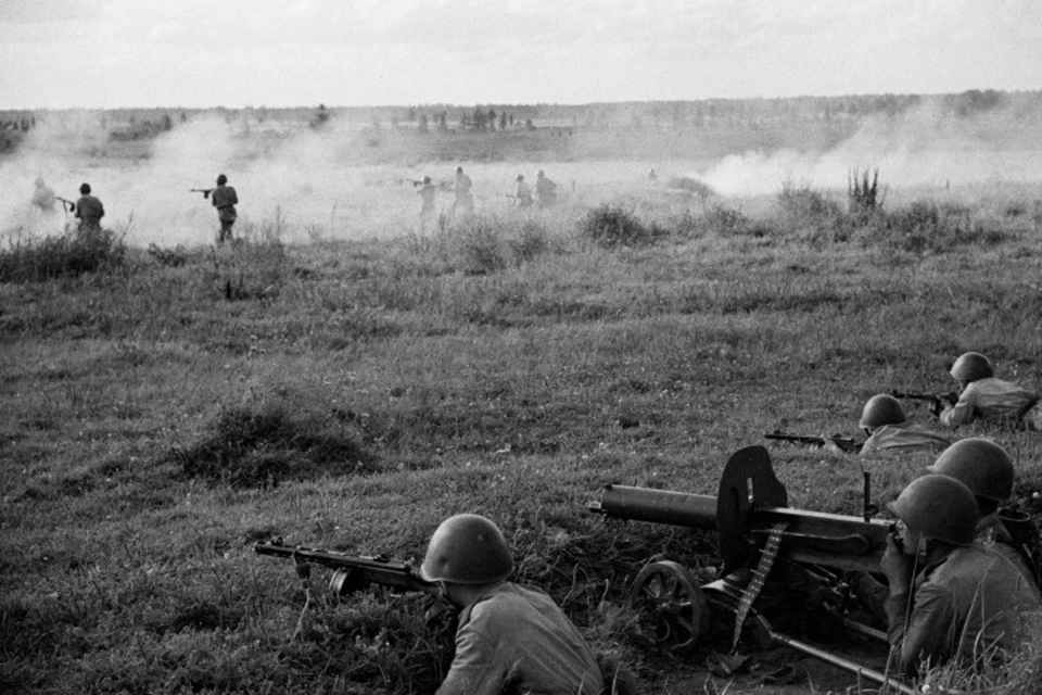 Расчет пулемета «Максим» прикрывает атаку советских солдат.