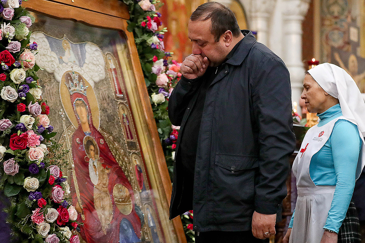 Мужчина кашляет перед иконой Божией Матери "Державная" во время литургии в Храме-Памятнике на Крови, Екатеринбург. Фото: Донат Сорокин/ТАСС