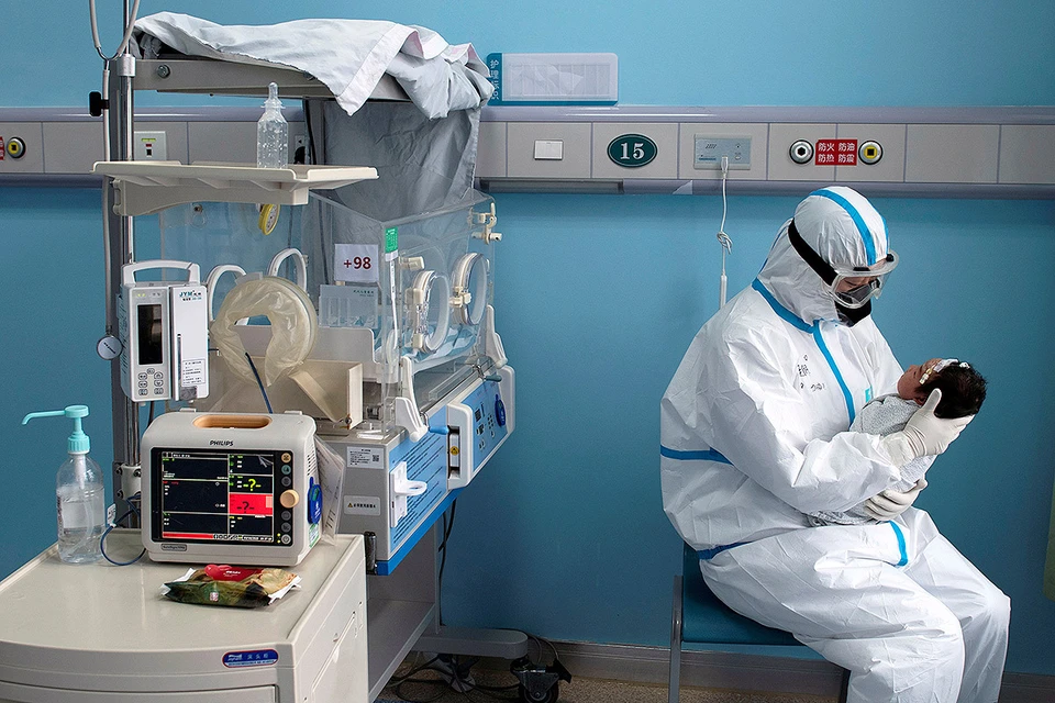 Медсестра с малышом, заразившимся коронавирусом, в госпитале китайского города Ухань.