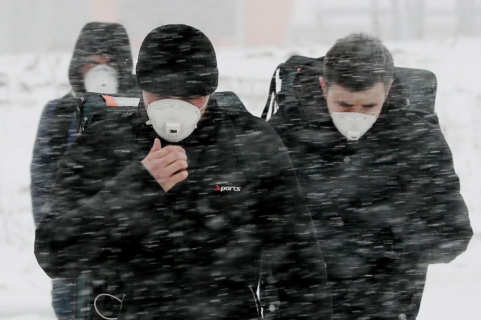 Мужчины в защитных масках у здания многопрофильного медицинского центра "Новомосковский", куда госпитализируют пациентов с подозрением на коронавирус COVID-19. Фото: Александр Щербак/ТАСС