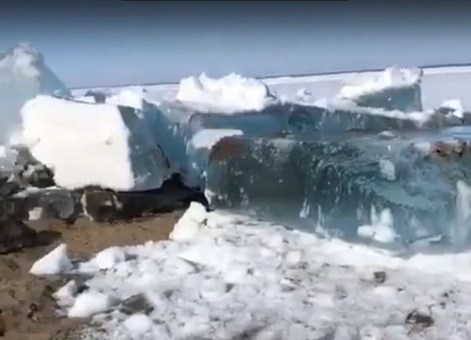 На видео лед загребает песчаный берег и глыбы льда переворачиваются. Скриншот видео