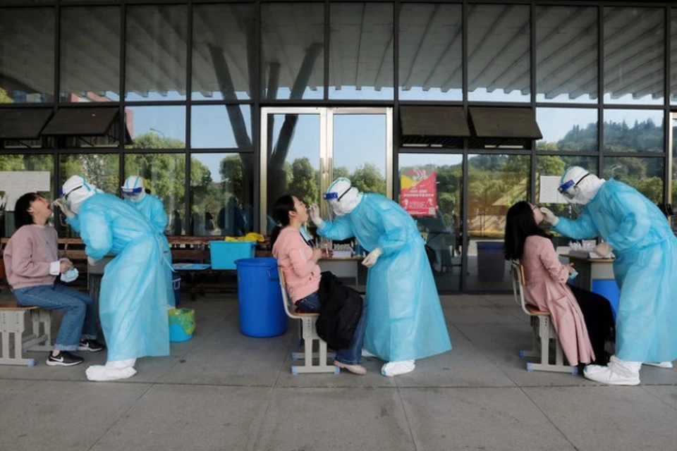 Медики проверяют людей на коронавирус в Пекине
