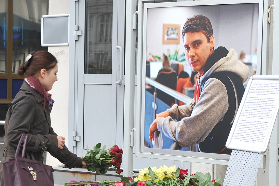 Люди приносят цветы в память о погибшем на Украине фотокорреспонденте МИА `Россия сегодня` Андрее Стенине к зданию агентства, сентябрь 2014 года.