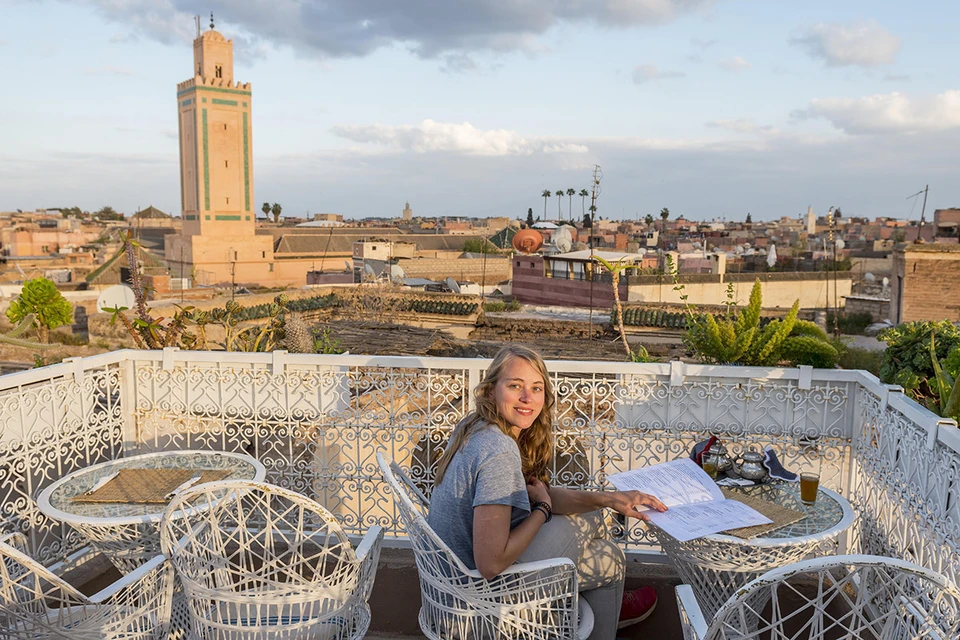 Туристка завтракает в кафе с видом на центр города Марракеш.