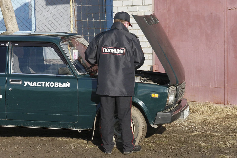 Алтайский край. Участковый полицейский у служебного автомобиля.