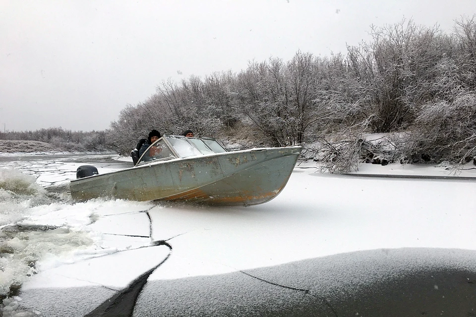 Река уже замёрзла, но первый лёд легко разбивается носом моторной лодки