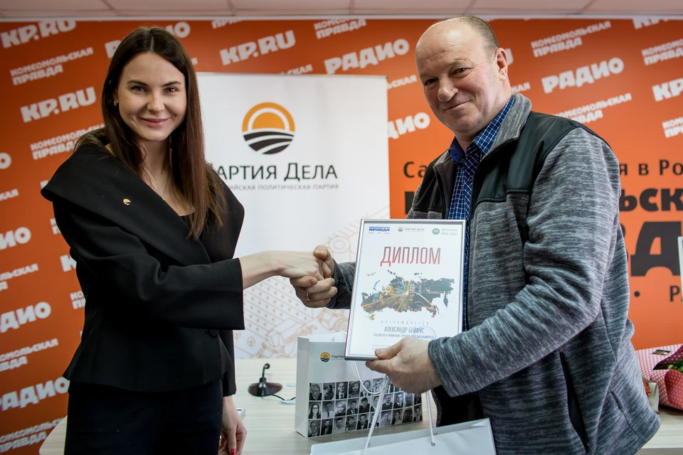 Екатерина Ситникова поздравляет победителя фотоконкурса "Лица труда" Александра Бейфуса