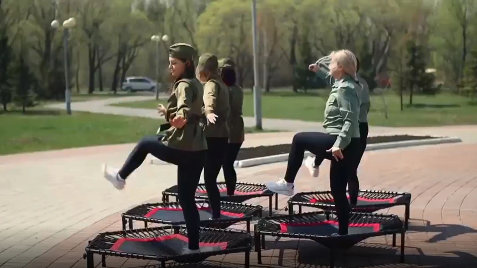 Девушки в имитации военных гимнастерок и спортивных штанах решили поздравить омичей, прыгая возле мемориала погибшим людям. Фото: скриншот видео