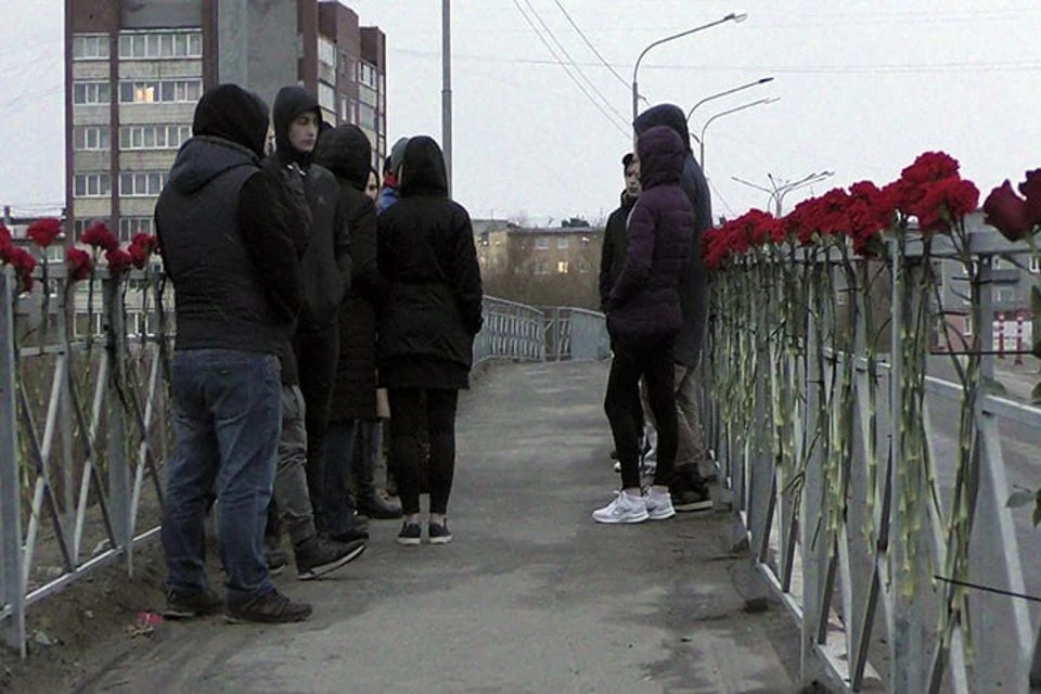 Множество ярко-красные гвоздик привязали к перилам переправы. Фото: hibinform.ru