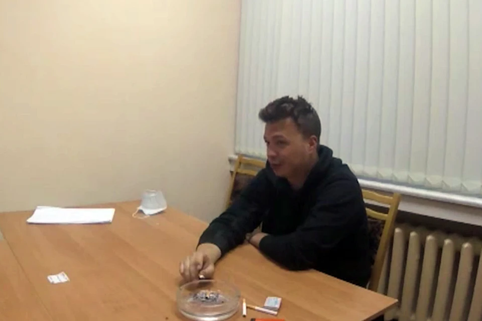 Роман Протасевич сидит за столом на фоне белых жалюзи. Выглядит раскованно, словно дает очередное будничное интервью