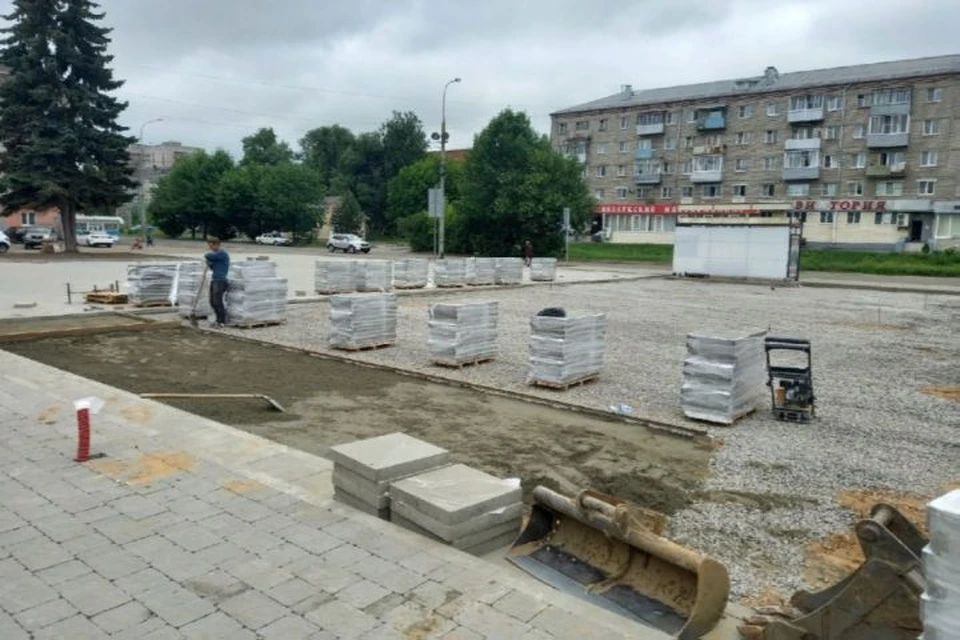 Рабочие завершают укладку тротуарной плитки.