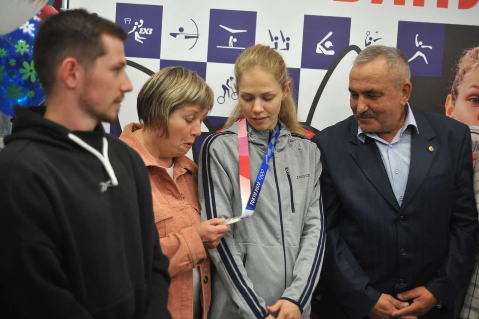 Мама Татьяны подержала в руках Олимпийскую медаль.