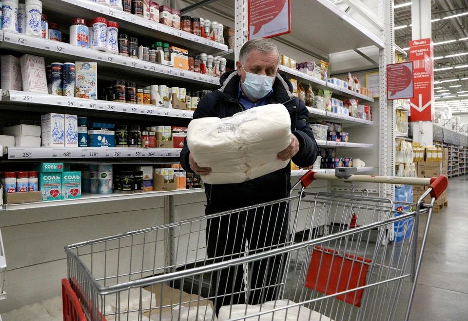Покупатель нагружает тележку упаковками сахара. Фото: Евгений Софийчук/ТАСС