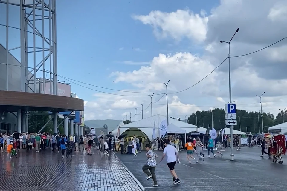 Гости фестиваля убегают от дождя