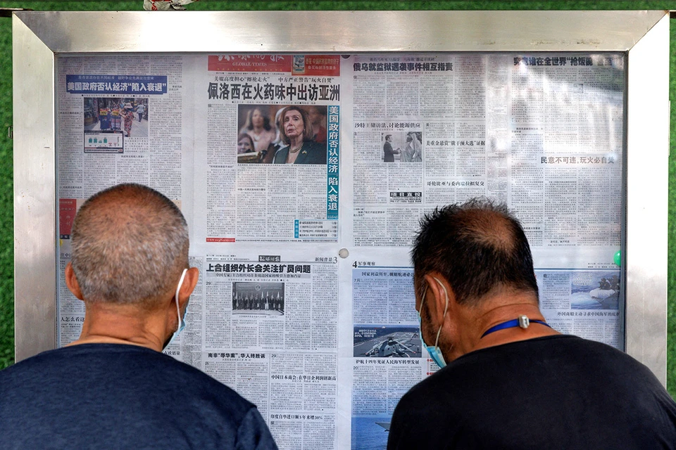 Жители Пекина изучают прессу с новостями о поездке Нэнси Пелоси на Тайвань.