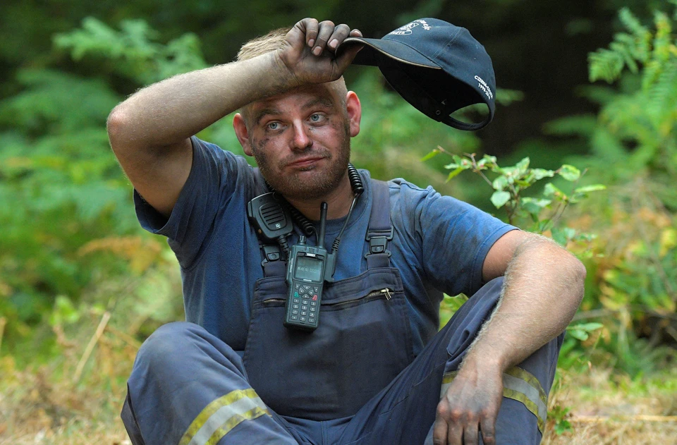 Пожарный на месте тушения очага огня в лесу на границе Германии и Чехии.