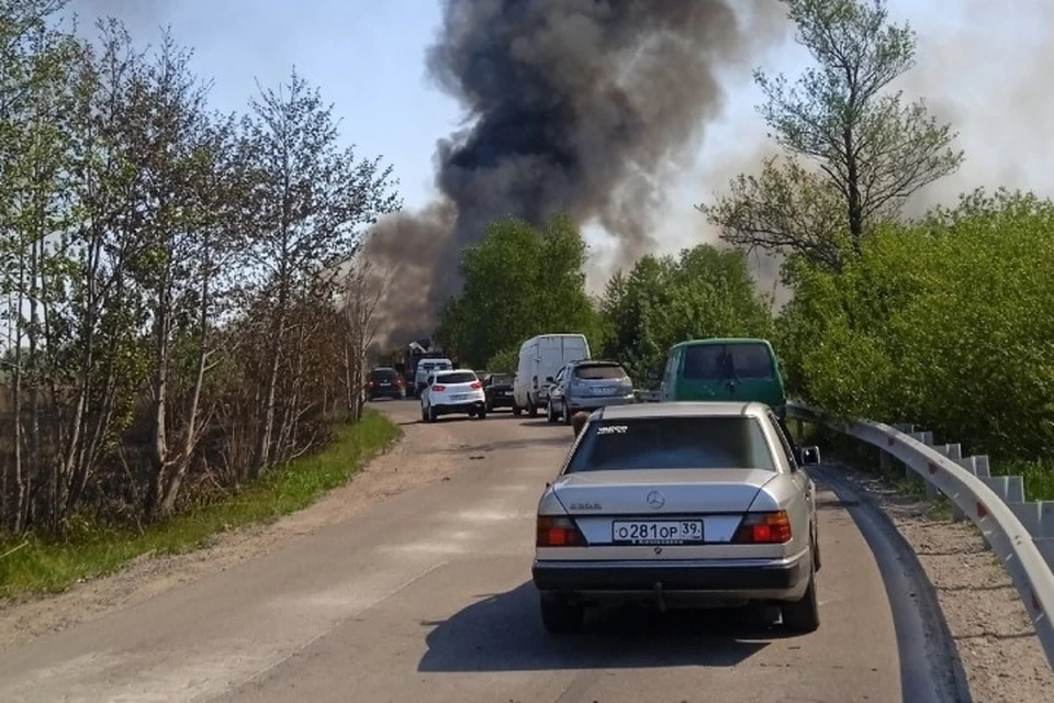 Над местом пожара поднимается густой столб дыма.