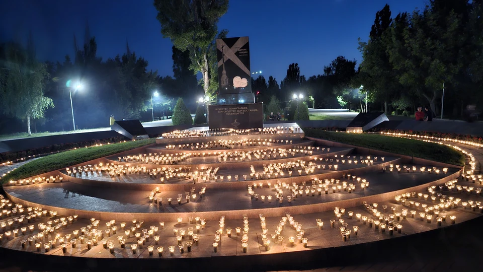 Участники акции у памятника блокадникам Ленинграда в Бишкеке свечами выложили грузовик с первым продовольствием, проехавшим по «Дороге жизни» , линии прожекторов и разорванное блокадное кольцо.