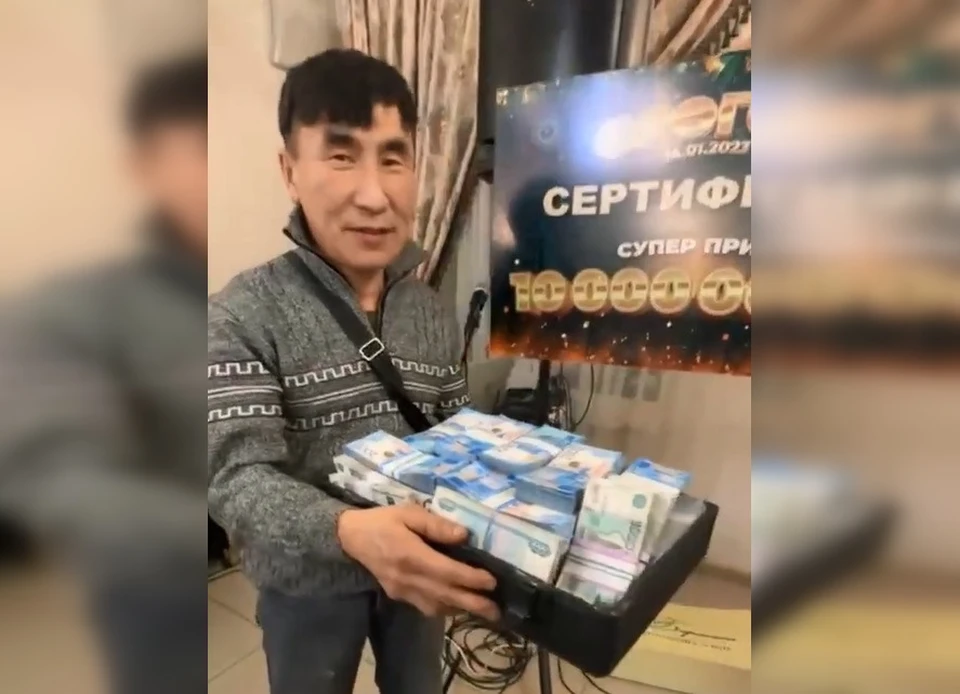 Гаврил Терентьев получает 10 миллионов, выигранных в лотерее, которую позже назовут незаконной. Фото: скриншот видео