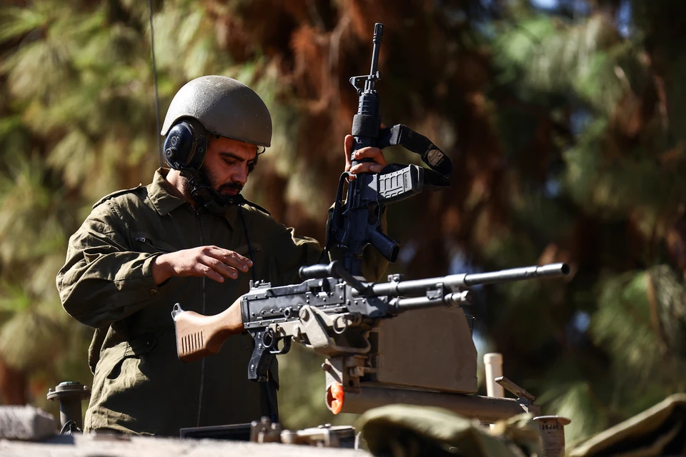 Израильский танкист проверяет пулемет перед началом операции в Газе.
