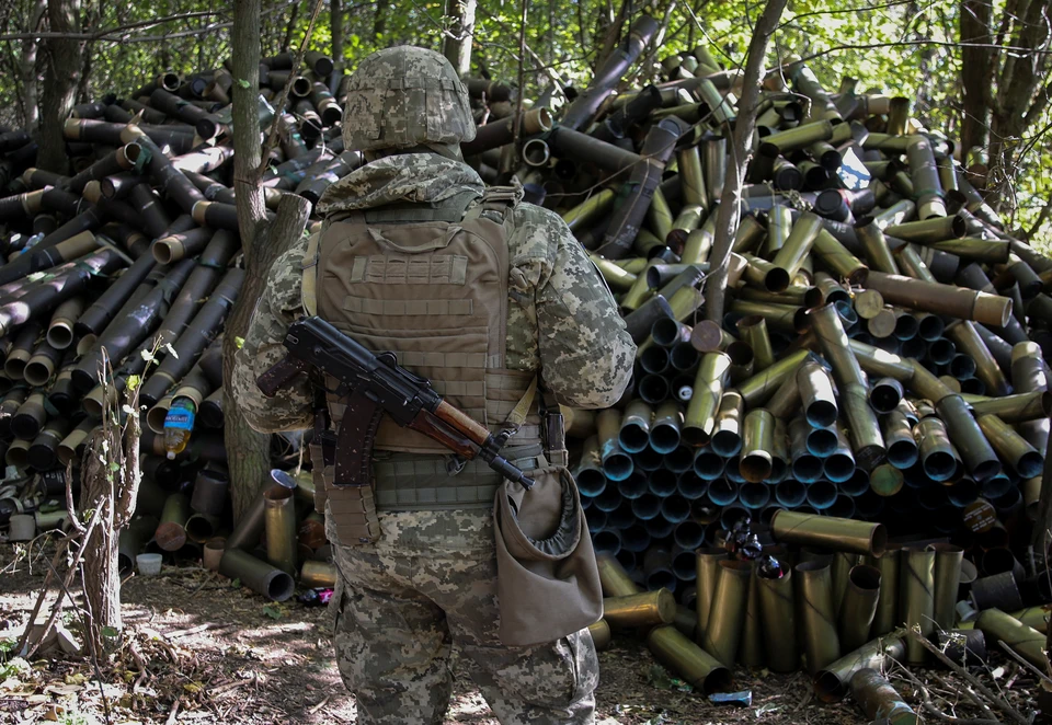Украинский артиллерист у груды гильз от снарядов.