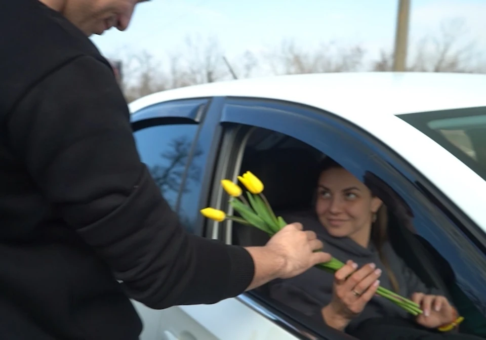 Женщинам дарят цветы в преддверии 8 марта. Фото - скришот с видео