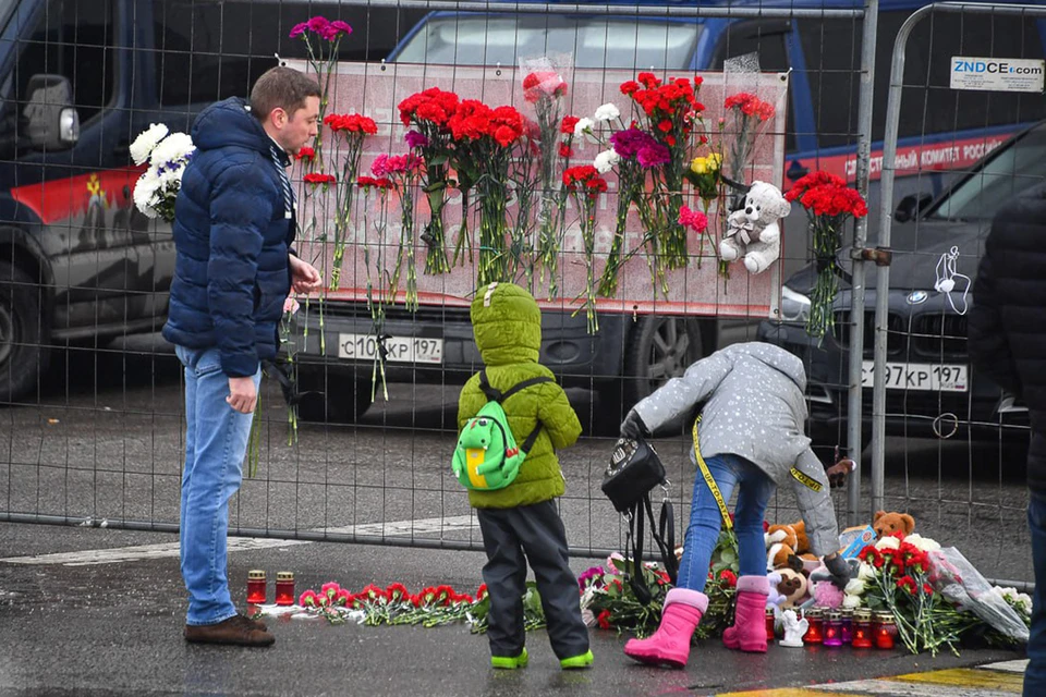 Люди несут цветы на место трагедии