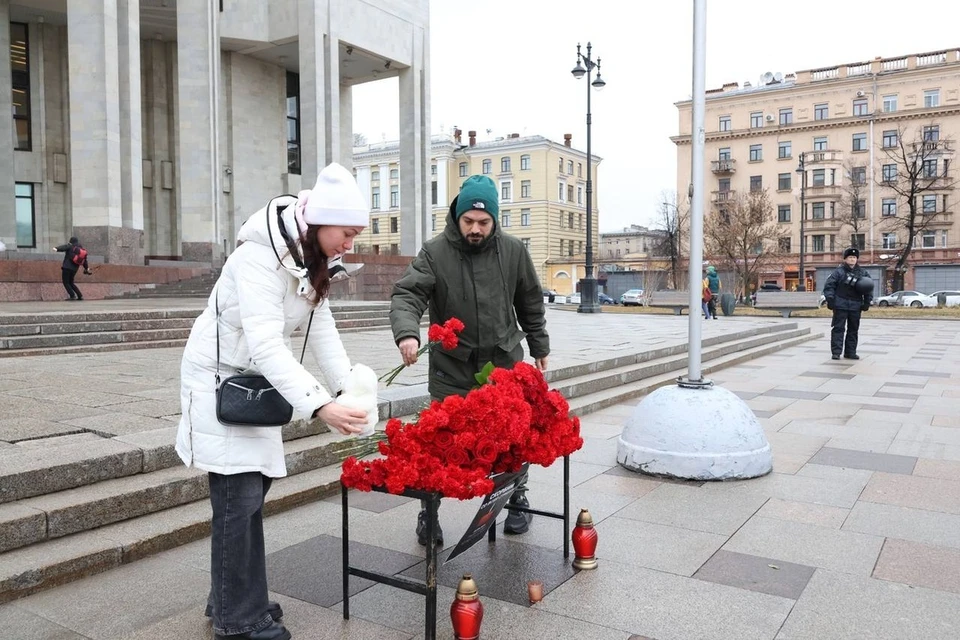 Петербуржцы с самого утра несут к РНБ цветы и игрушки.