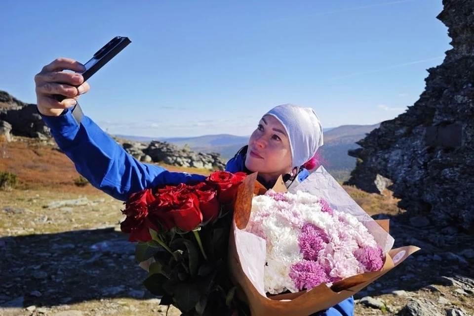 Оксана Соло на перевале Дятлова с букетами цветов, подаренными ей в честь финиша. Фото: vk.com/okslytkina
