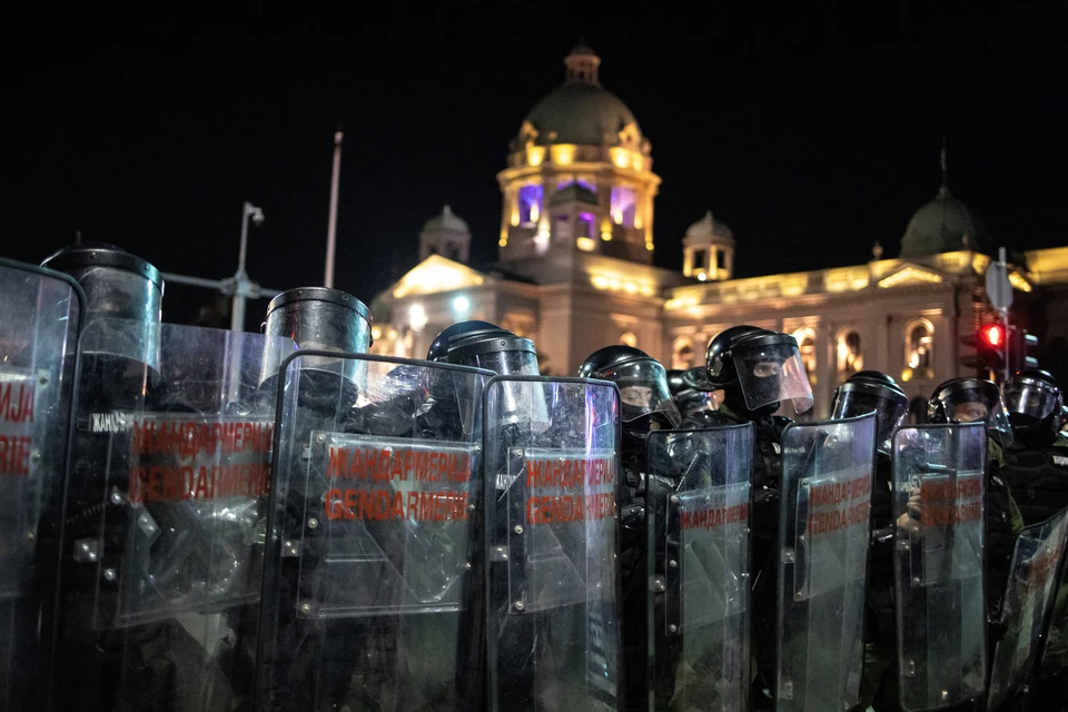 В Белграде полиция выставила кордон между двумя группами протестующих, которые кидают бутылки и петарды.