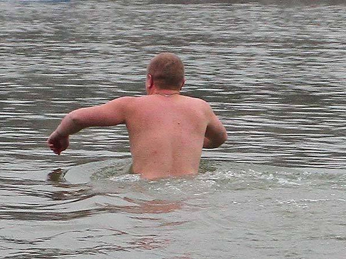 Мужчина купается в речке