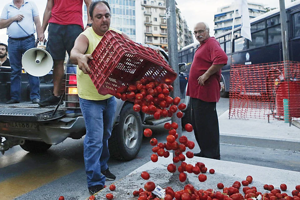 Греческие фермеры выбрасывают помидоры, предназначенные для экспорта в Россию, у здания правительства, в знак протеста против санкций