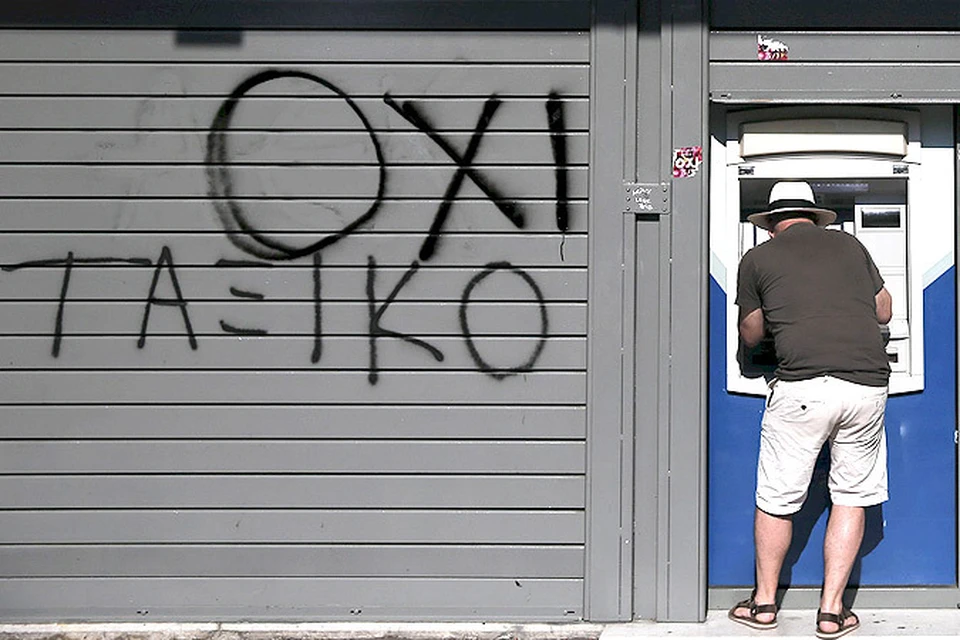 Мужчина пытается снять деньги в одном из банкоматов греческой столицы.
