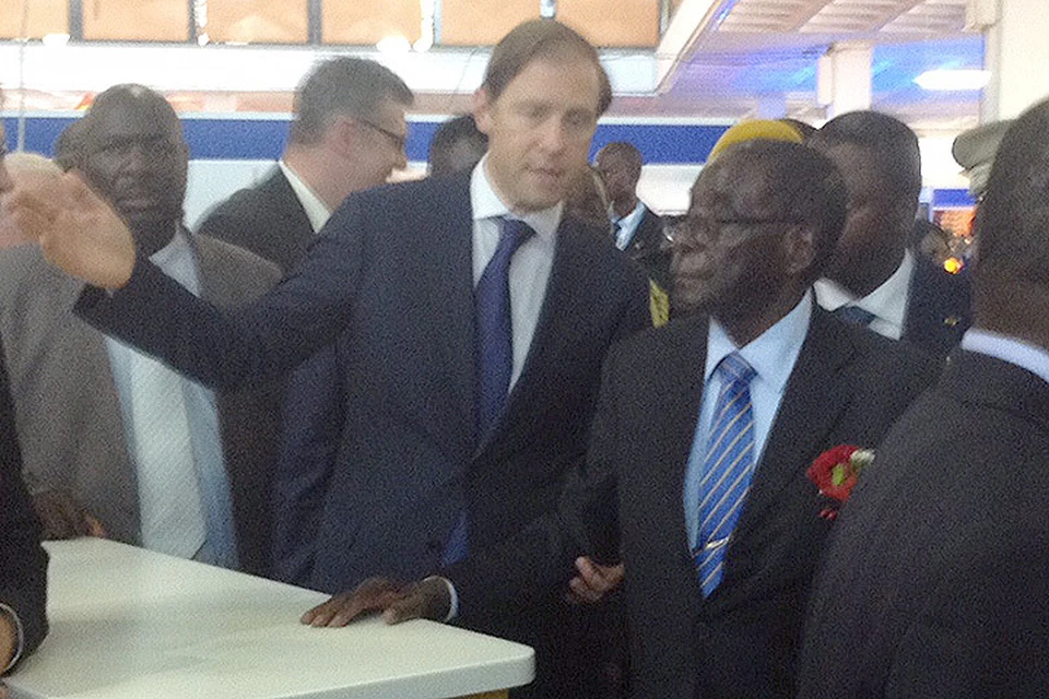 Министр промышленности и торговли Денис Мантуров показывает президенту Зимбабве Роберту Мугабе российский павильон на международной выставке.
