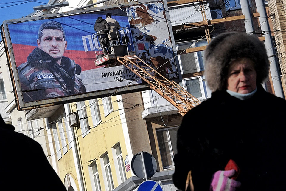 Размещение плакатов в память об ополченце на улицах Донецка.