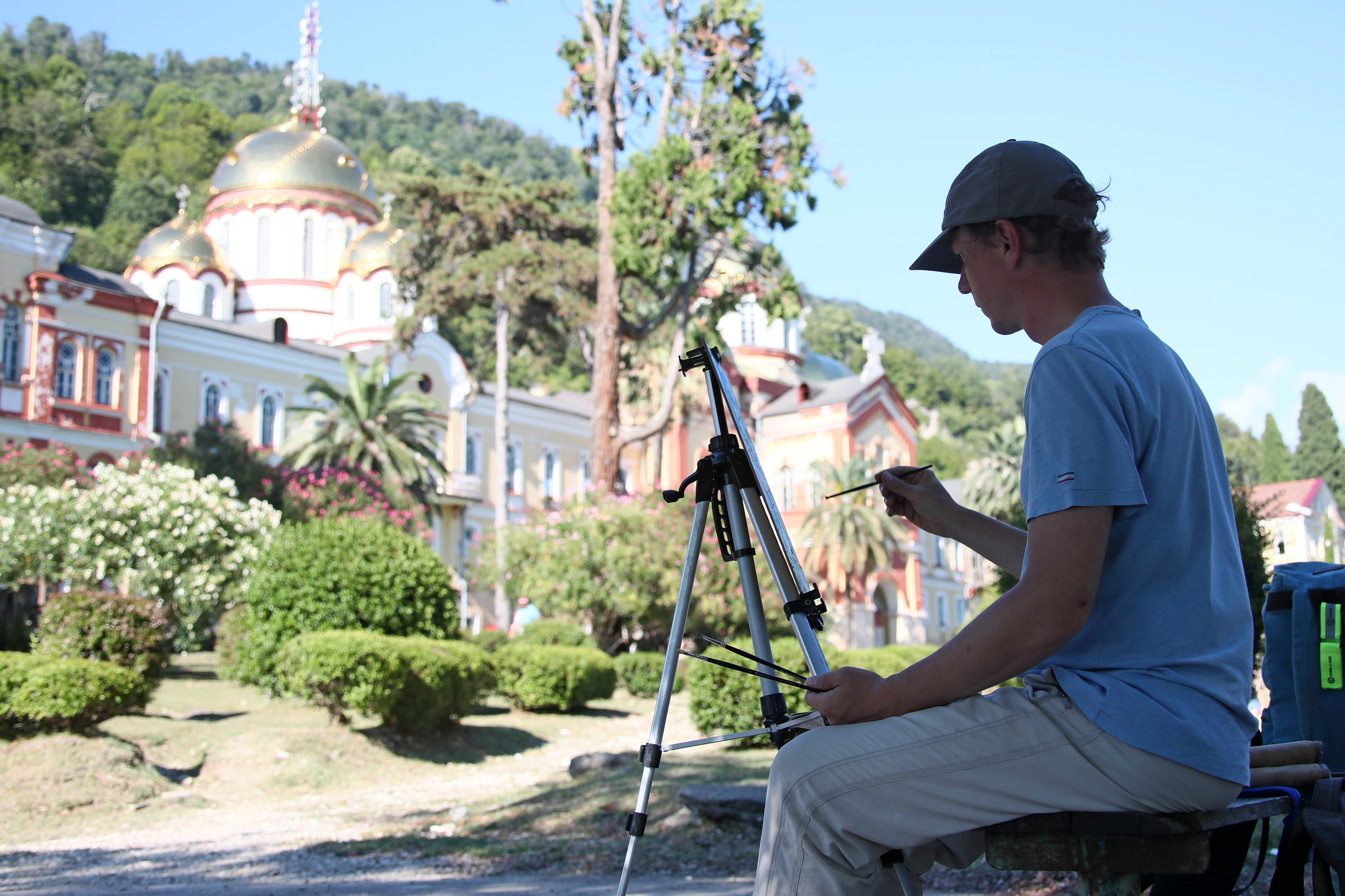 Художник у комплекса зданий Ново-Афонского Симоно-Кананитского монастыря в Абхазии. Фото: Дмитрий Феоктистов/ТАСС
