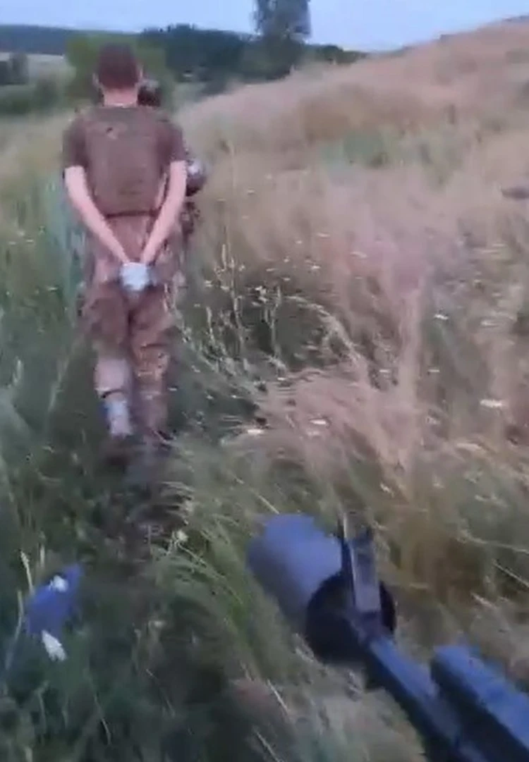 Кадр из личного видео Харама - спиной к нам топает очередной украинский пленный.